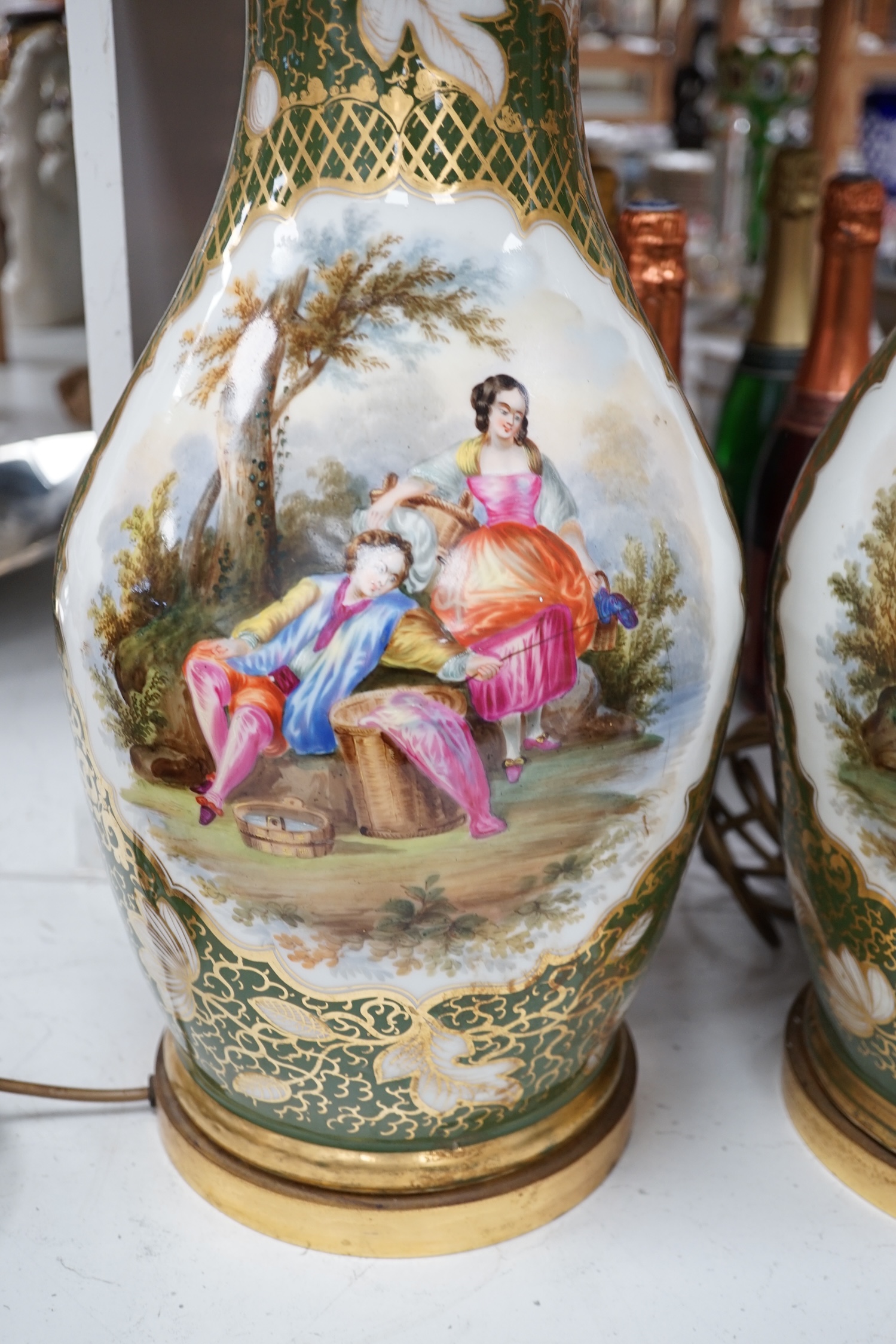 A large pair of Continental porcelain vases converted to lamps, hand painted with figures before landscapes, 51cm high excluding the fitting. Condition - fair to good. Untested